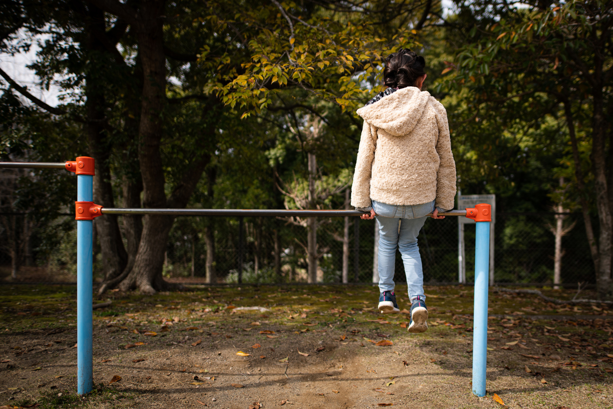 Child sitting on the horizontal bar