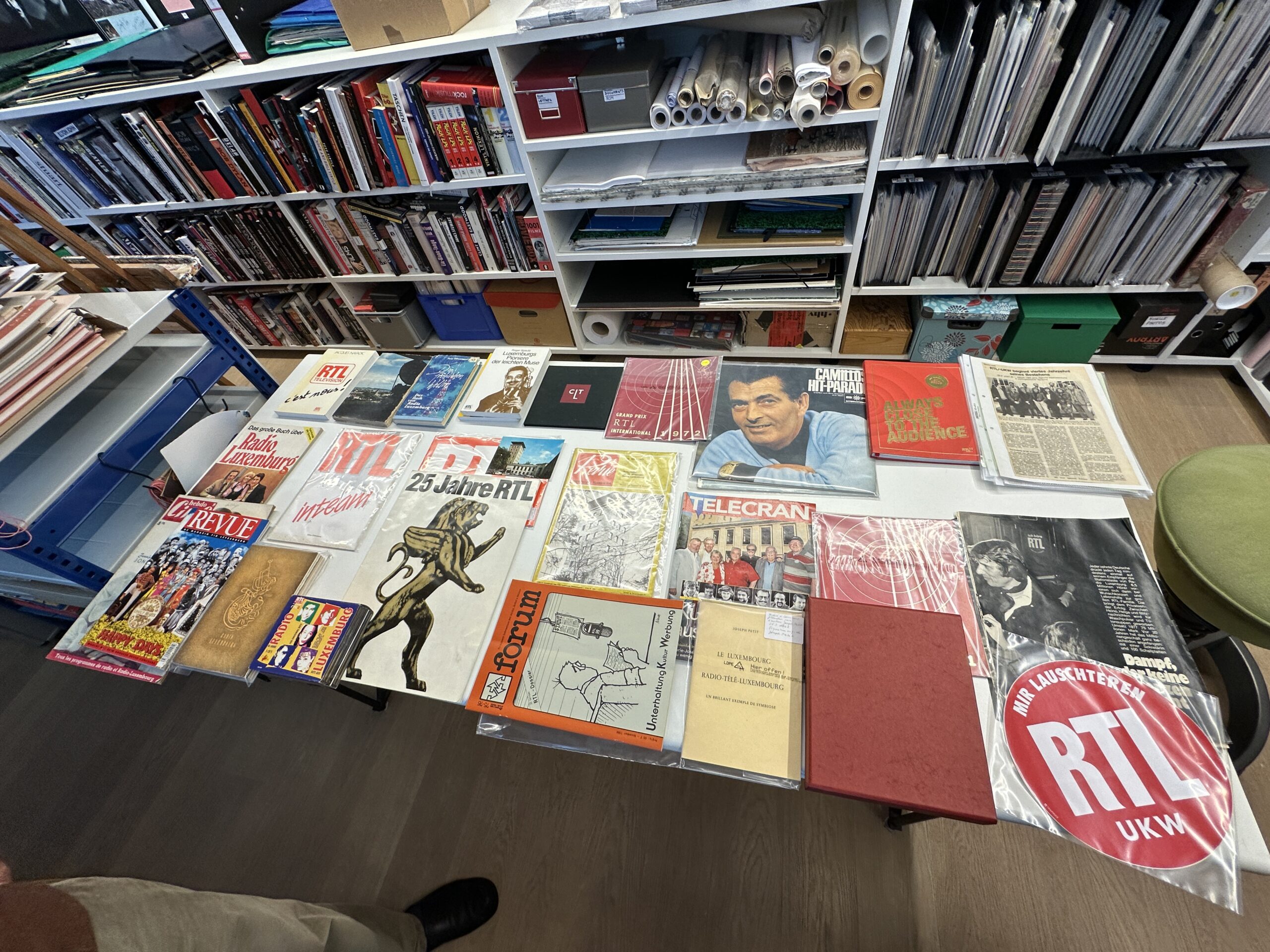 Un large choix de magazines et de souvenirs soigneusement disposés sur une table chez Romain Hoffmann