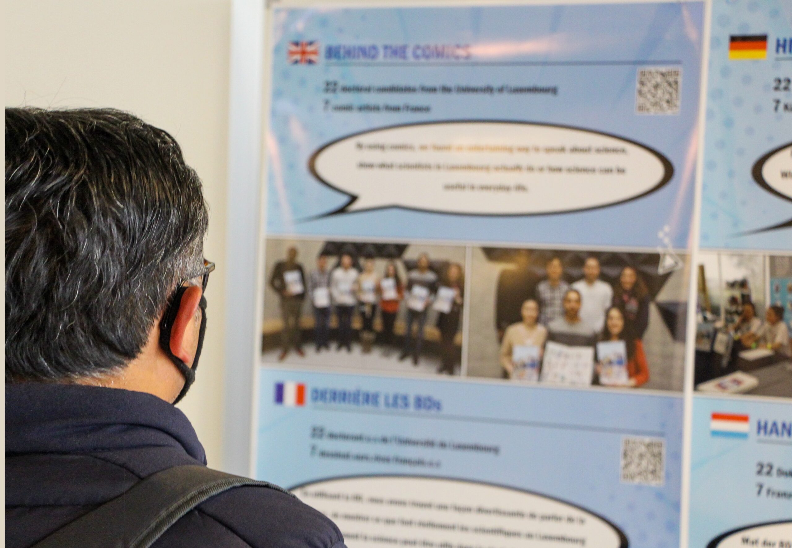 a man looking at an informative poster that talks about the DESCOM science comics