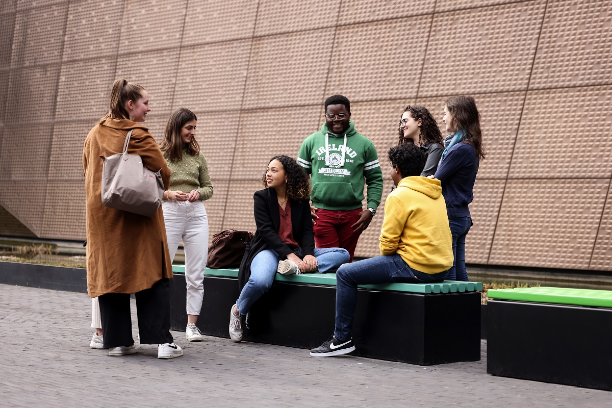 Group of students chatting outside, next to the MAE