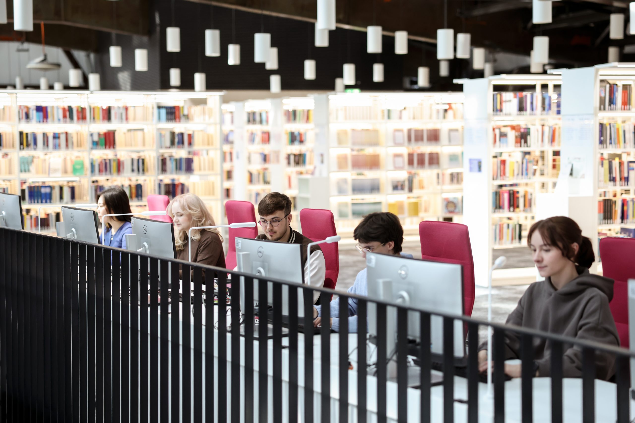 Group of students, sitting at computers at the library 